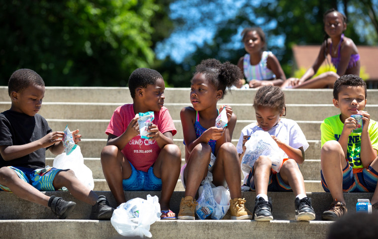 Kids on the steps at Dempsey Aquatic Center where the Cincinnati Public Schools serve both breakfast and lunch during the summer as part of a federally funded Summer Food Service Program in June 2019.
