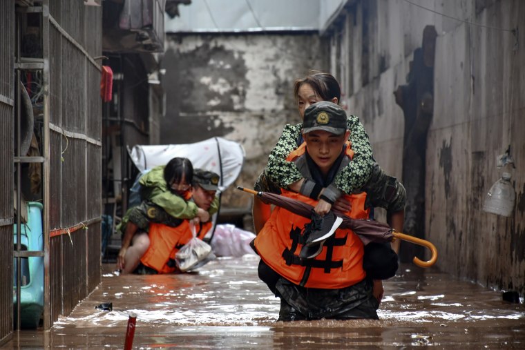 Members of the Chinese People's Armed Police Force evacuate flood trapped residents Chongqing, China