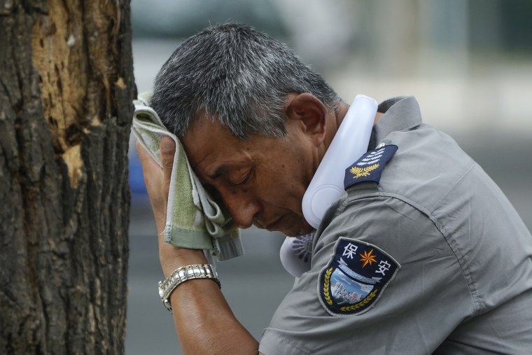 A security guard wipes off sweat in Beijing in July. 