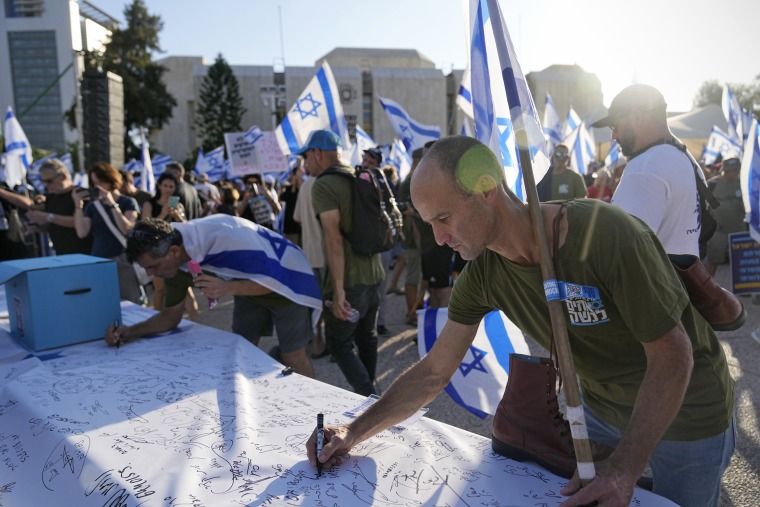 Israeli military reservists sign a declaration of refusal to report for duty to protest plans to overhaul the judicial system, in Tel Aviv, on July 19, 2023. 