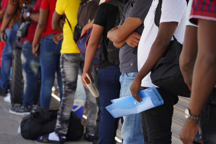 Migrants at the Hidalgo, Texas, port of entry wait for the screening appointment they scheduled on the CBP One mobile app.