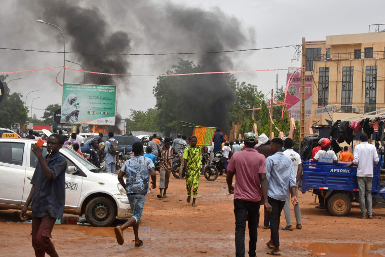 Smoke billows as supporters of Niger's security forces attack the headquarters of the Nigerien Party for Democracy and Socialism, the party of overthrown President Mohamed Bazoum, in Niamey on July 27, 2023. 