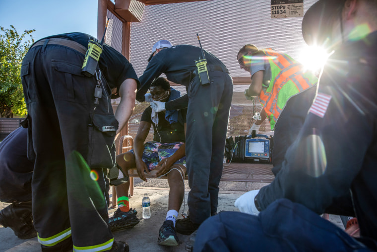 Firefighters from Phoenix Fire Engine 18 start a breathing treatment for a resident having trouble breathing during a heat wave in Phoenix on July 20, 2023.
