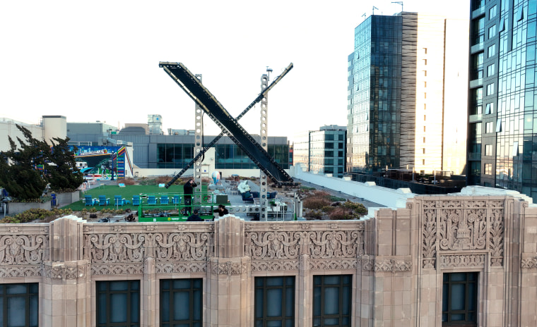 Workers install a large X on the roof of the former Twitter headquarters in San Francisco