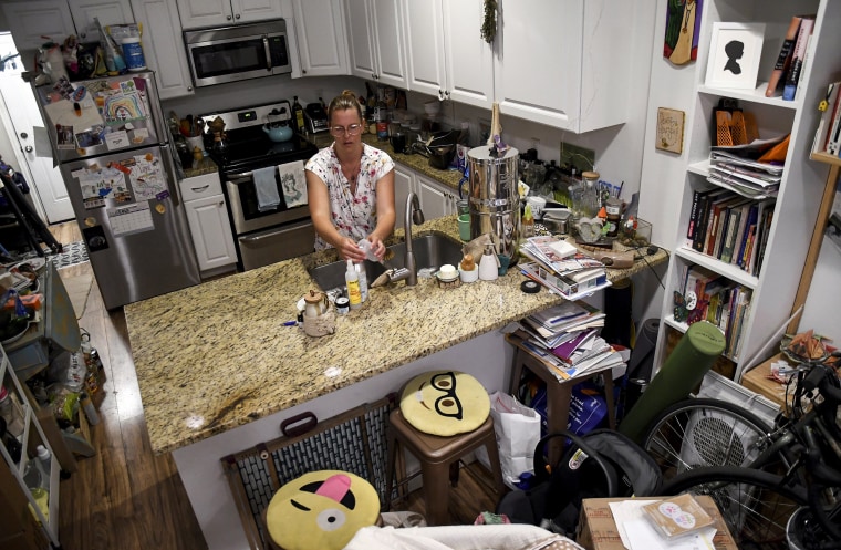 Amanda Morian washes dishes at home in Denver's Globeville neighborhood on July 24, 2023.