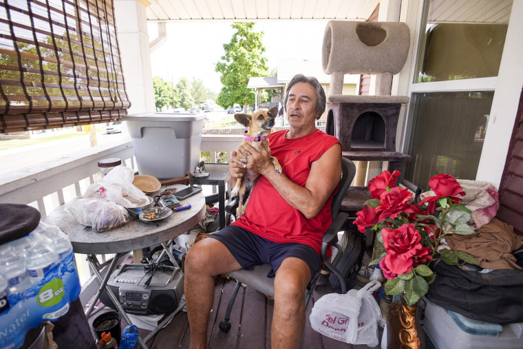 Ben Gallegos at home with his dog Coca Smiles as the daytime high temperature soars toward triple digits on July 27, 2023, in Denver.