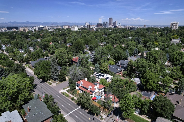 Mansions dot a tree-lined street in the Country Club neighborhood in Denver on July 24, 2023.
