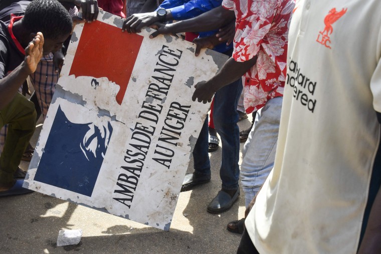 Protesters hold a sign taken from the French Embassy in Niamey, Niger, during a demonstration supporting the junta on July 30, 2023.