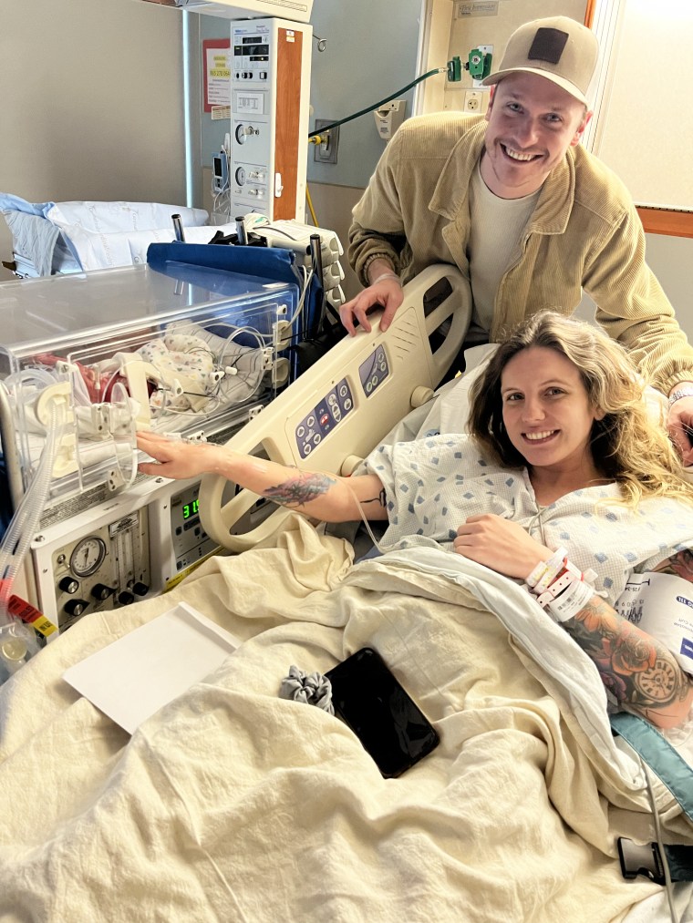 Meghan Huston and her husband, visiting one of her newborn twin sons shortly after giving birth.