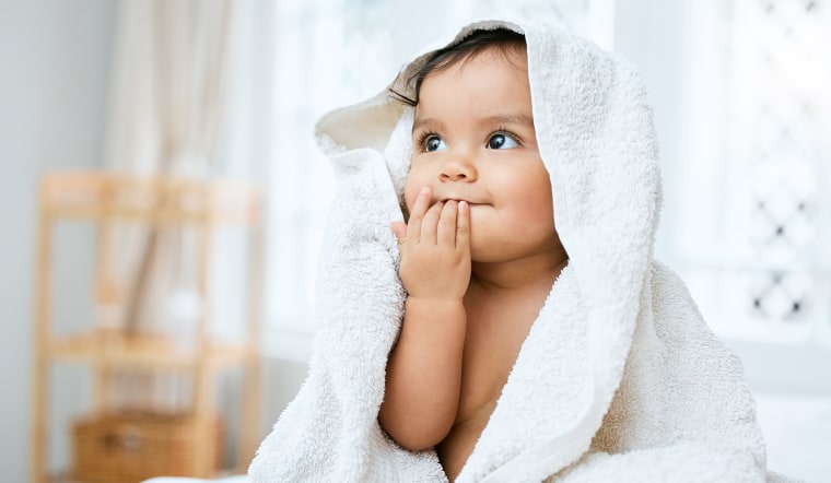 Shot of an adorable baby covered in a towel after bath time