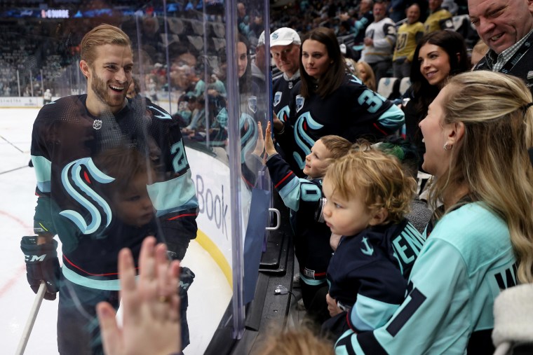 Alex Wennberg #21 of the Seattle Kraken greets his wife, Felicia, and son, Rio, during warmups on April 13, 2023 in Seattle.