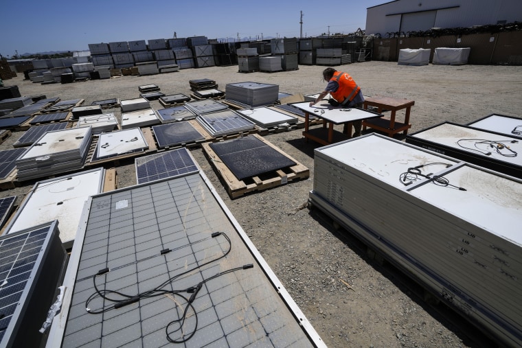 Image: Dwight Clark inspects a used solar panel at We Recycle Solar on June 6, 2023, in Yuma, Ariz.
