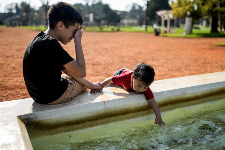 A child dips his hand in a fountain at a park in Buenos Aires, Argentina on Aug. 2, 2023. 