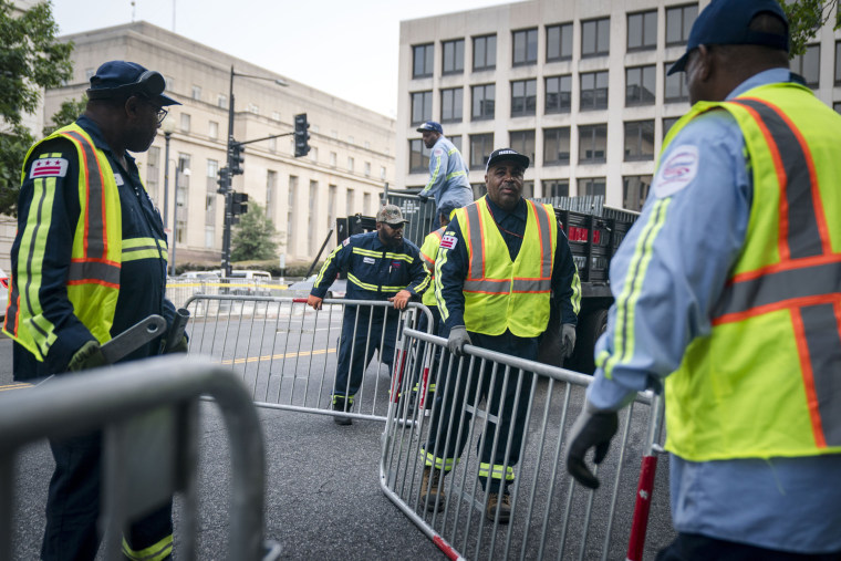 Workers install security fencing along 3rd St. in Washington, D.C.