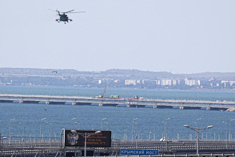 Image: A Russian military helicopter flies over damaged parts of the Crimean Bridge, which connects the Russian mainland to the Crimean peninsula and is a key supply route for the Russian war efforts in Ukraine, on July 17.