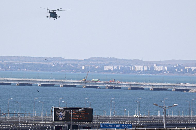 Image : Un hélicoptère militaire russe survole des parties endommagées du pont de Crimée, qui relie le continent russe à la péninsule de Crimée et est une voie d'approvisionnement clé pour les efforts de guerre russes en Ukraine, le 17 juillet.