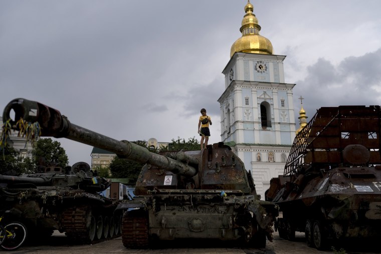 Image: A boy stands atop destroyed Russian tanks on display in Kyiv on June 30.