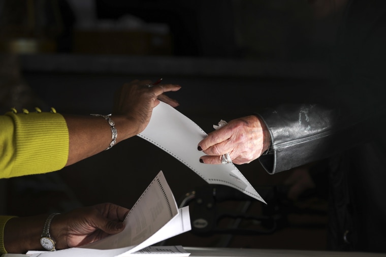 RIDGELAND, MS - NOVEMBER 27: A poll worker hands a ballot to a voter at a polling place at Highland Colony Baptist Church, November 27, 2018 in Ridgeland, Mississippi. Voters in Mississippi head to the polls for today's special runoff election, where  Democratic candidate for U.S. Senate Mike Espy is running in a close race with appointed Republican Senator Cindy Hyde-Smith (R-MS).