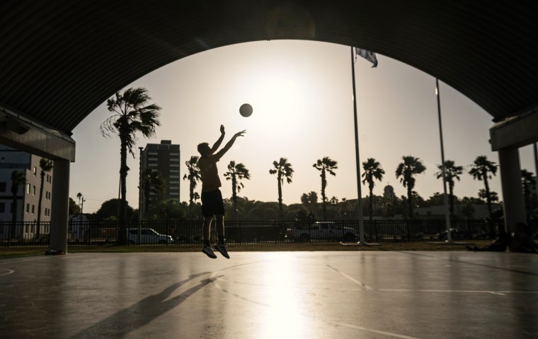 A resident plays basketball during a heat wave in Corpus Christi, Texas on July 20, 2023. 