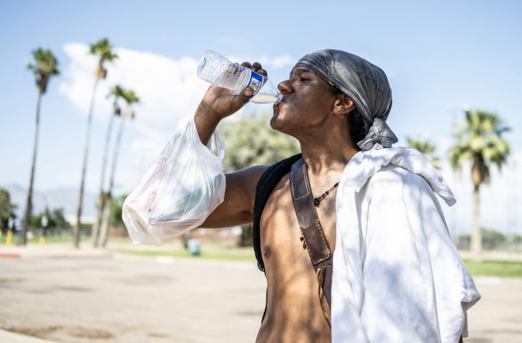 Alonzo McAdams drinks a bottle of water from a Salvation Army truck handing out water, and other supplies for the homeless in Tucson on July 26, 2023. 