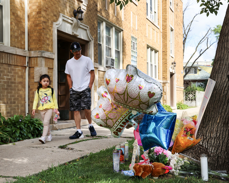 Neighbors pass by a memorial for an 8 year-old girl shot and killed outside of her Portage Park apartment in Chicago on Monday, Aug. 7, 2023.
