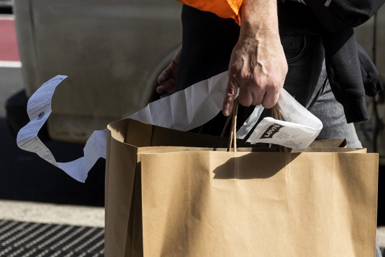 A shopper holds onto a receipt in New York on March 22, 2023.