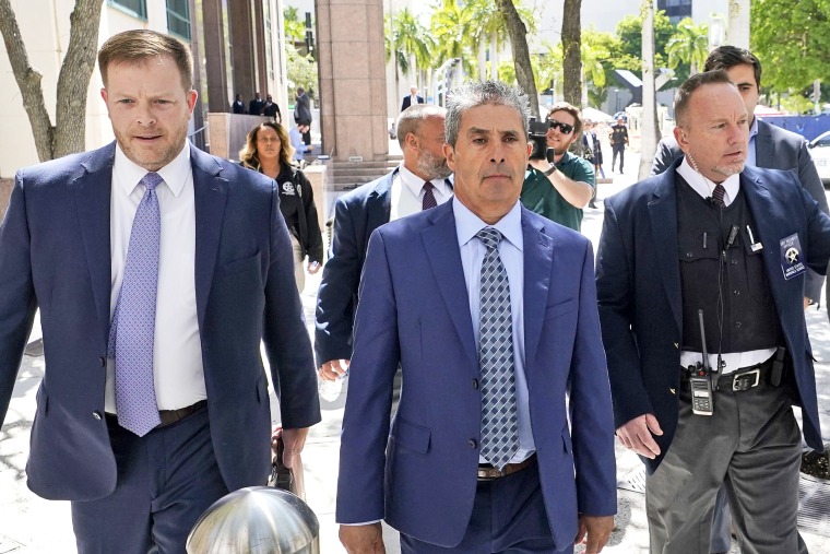 Carlos De Oliveira, center, an employee of Donald Trump's Mar-a-Lago estate, leaves a court appearance with attorney John Irving, left, at the James Lawrence King Federal Justice Building, Monday, July 31, 2023, in Miami. De Oliveira, Mar-a-Lago's property manager, was added last week to the indictment with Trump and the former president's valet, Walt Nauta, in the federal case alleging a plot to illegally keep top-secret records at Trump's Florida estate and thwart government efforts to retrieve them.
