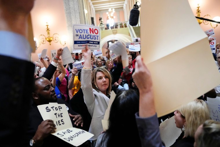 House Minority Leader Allison Russo, center, speaks with protesters in the rotunda of the Ohio Statehouse on May 10, 2023, following a vote on whether to create an August special election for a resolution that would increase the voter threshold to 60 percent for constitutional amendments. 