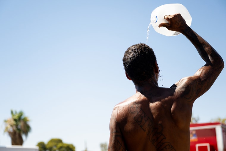 Image; A man pours water over his head from a gallon jug amid soaring temperatures in Phoenix on July 16. 