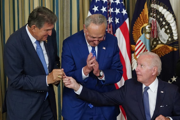 President Joe Biden hands a pen to Sen. Joe Manchin during a signing ceremony for H.R. 5376, the Inflation Reduction Act of 2022, in the State Dining Room of the White House on Aug. 16, 2022. 