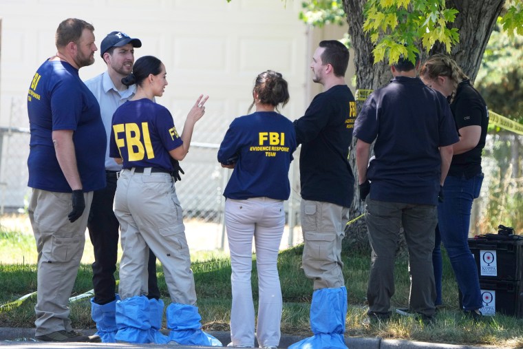 FBI officials and other law enforcement officers stand outside the home of Craig Robertson who was shot and killed by the FBI in a raid on his home this morning on August 9, 2023 in Provo, Utah. The FBI was investigating alleged threats by Robertson to President Biden who is visiting Salt Lake City today and tomorrow.