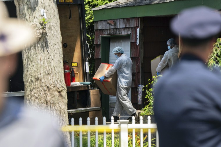Crime laboratory officers removes boxes as law enforcement searches the home of Rex Heuermann