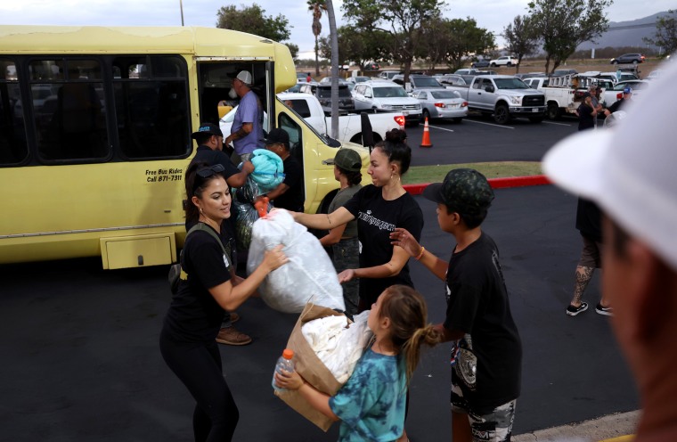 Image: Volunteers with King's Cathedral Maui unload donations of supplies in Kahului on Thursday. The church is providing food and shelter for displaced families.