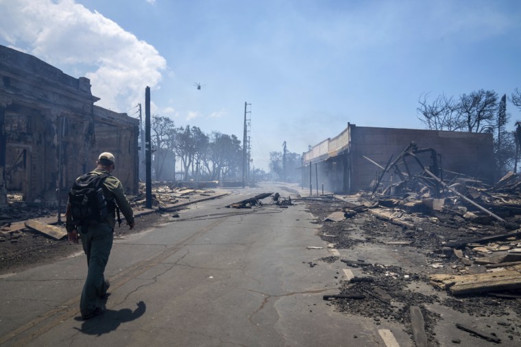 A man walks past wreckage in the wake of wildfires in Lahaina on Wednesday.