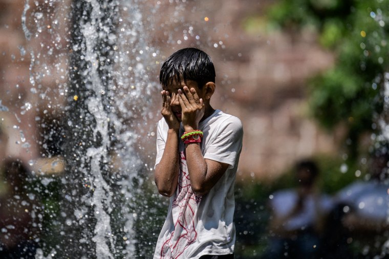 A boy cools off in a public fountain at a park in New York on July 26, 2023. 