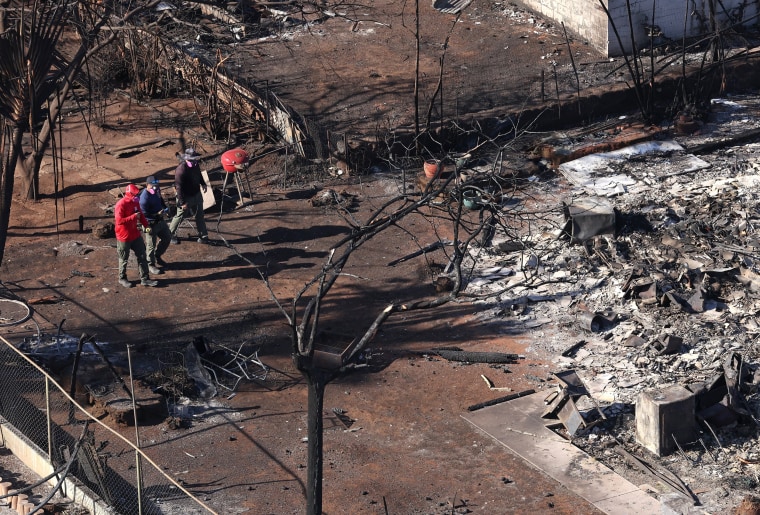 Search and rescue crews walk through a destroyed neighborhood on Aug. 11, 2023 in Lahaina, Hawaii. 
