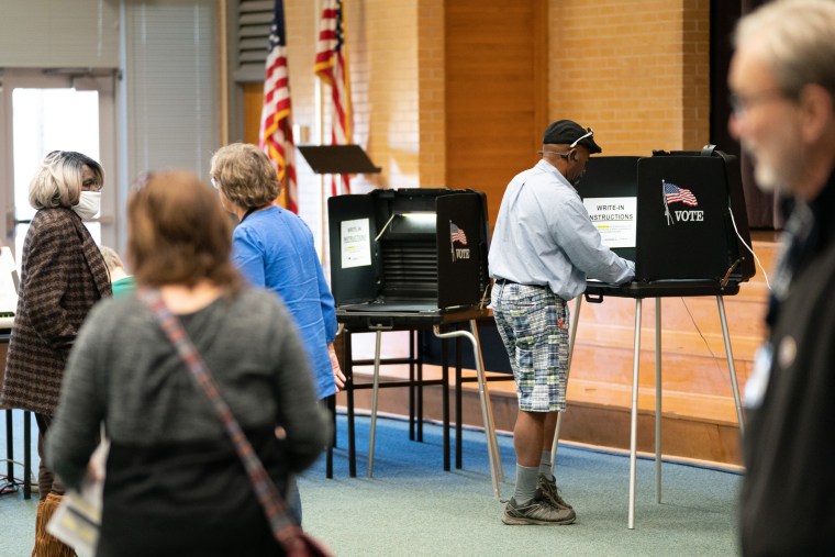 A voter fills out a ballot at a voting booth