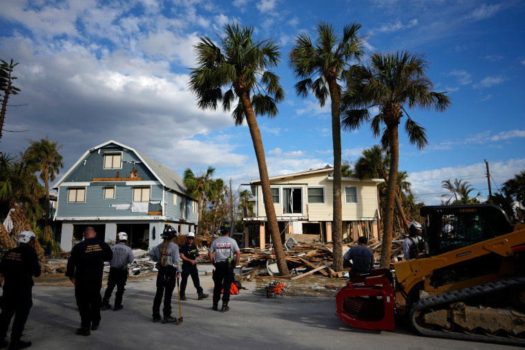 Members of Texas Task Force 1 search and rescue and Riviera Beach Fire Rescue work together in the search for remaining victims of Hurricane Ian, in Fort Myers Beach, Fla., on Oct. 5, 2022. 