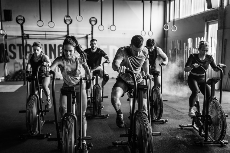 Group of people training on exercise bikes in a gym