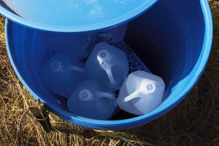 Sealed jugs of fresh water sit inside a water station for immigrants