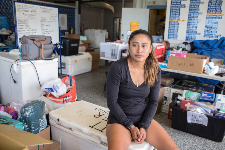 [15 August 2023 - Maui, HI] Coordinator Hiilei Luuwai waits to distribute supplies at the Hawaiian Canoe Club organize supplies for delivery to Lahaina.