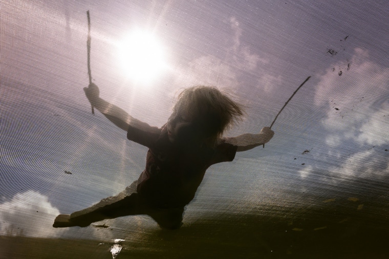  A child plays a trampoline in the front yard of his home in New Freeport, Pa., on March 29, 2023.