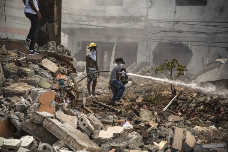 Firefighters work to extinguish a fire after an explosion in San Cristobal, Dominican Republic