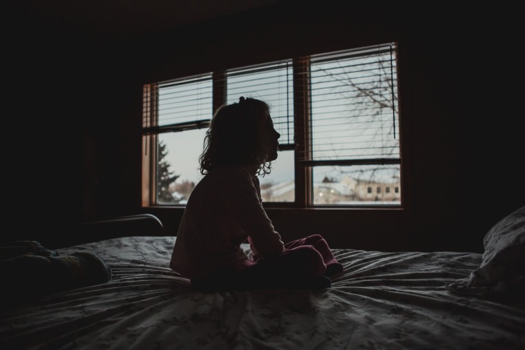 Silhouette of Little girl sitting on bed