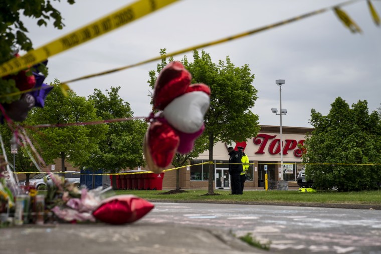 People gather at the scene of a mass shooting at Tops Friendly Market