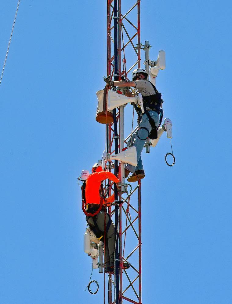 Tower technician install broadband transmitters on a  radio tower on the western edge of Emporia, Kansas in September 2022.
