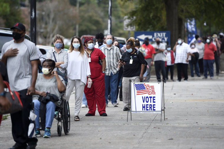 In this Oct. 12, 2020, file photo, people wait in line for early voting at the Bell Auditorium in Augusta, Ga. The sweeping rewrite of Georgia's election rules that was signed into law by Republican Gov. Brian Kemp Thursday, March 25, 2021, represents the first big set of changes since former President Donald Trump's repeated, baseless claims of fraud following his presidential loss to Joe Biden. Georgiaâ€™s new, 98-page law makes numerous changes to how elections will be administered, including a new photo ID requirement for voting absentee by mail.
