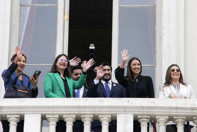 Congresswoman Nydia Velazquez, (D-NY), Santiago's Mayor Iraci Hassler, Congressman Maxwell Frost, (D-FL), Congressman Greg Casar, (D-TX), Congresswoman Alexandria Ocasio-Cortez, (D-NY), and Misty Rebik, chief of Staff for Sen. Bernie Sanders, wave to students from a City Hall balcony, in Santiago, Chile, Thursday, Aug. 17, 2023. The US delegation traveled to the South American country to learn about efforts to defend its democracy ahead of the 50th anniversary of the military coup led by Gen. Augusto Pinochet.