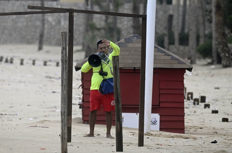 Local government lifeguard Julio Cesar Tehuitzin gives instructions to people approaching the beach in Los Cabos, Baja California State, Mexico, during the passage of Hurricane Hilary on Aug. 19, 2023. 
