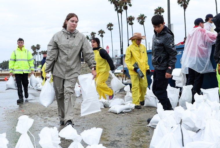 People fill sandbags at Belmont Shore Beach in Long Beach, Calif., on Aug. 20, 2023.